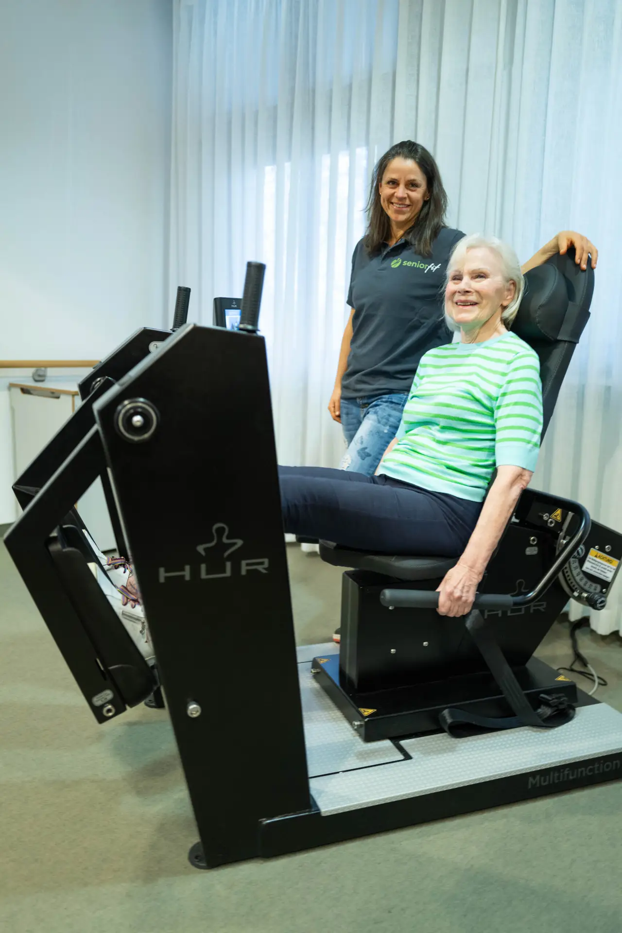 Seniorin beim Beintraining am HUR-Gerät mit persönlicher Betreuung