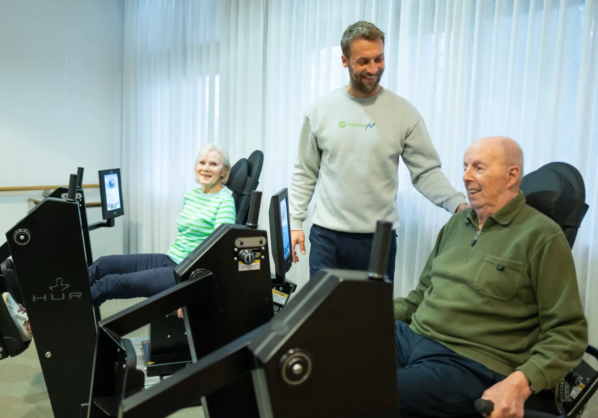 Bewohner trainieren an HUR-Geräten unter Anleitung von SeniorFit