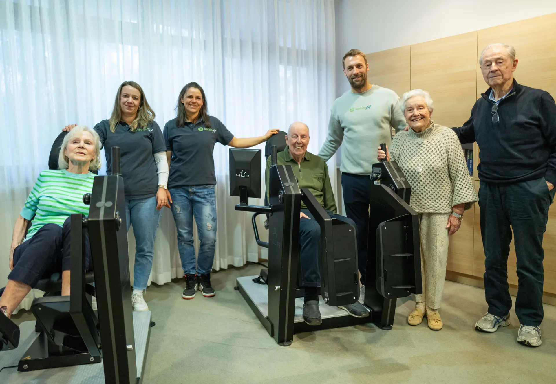 Das SeniorFit-Team mit Bewohnerinnen und Bewohnern im Trainingsraum