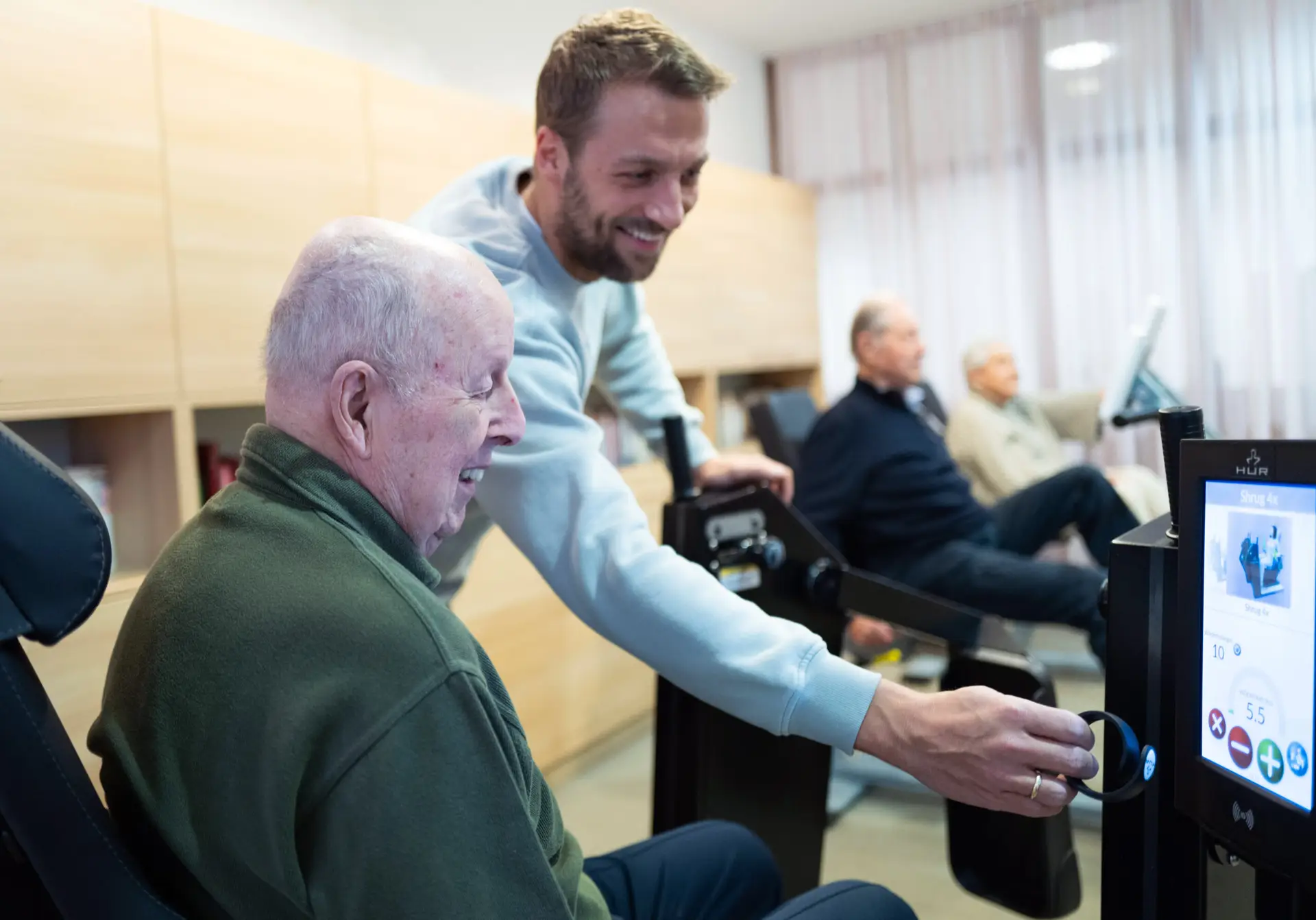 SeniorFit-Trainer begleitet Senioren beim Gruppentraining im Bewegungsraum